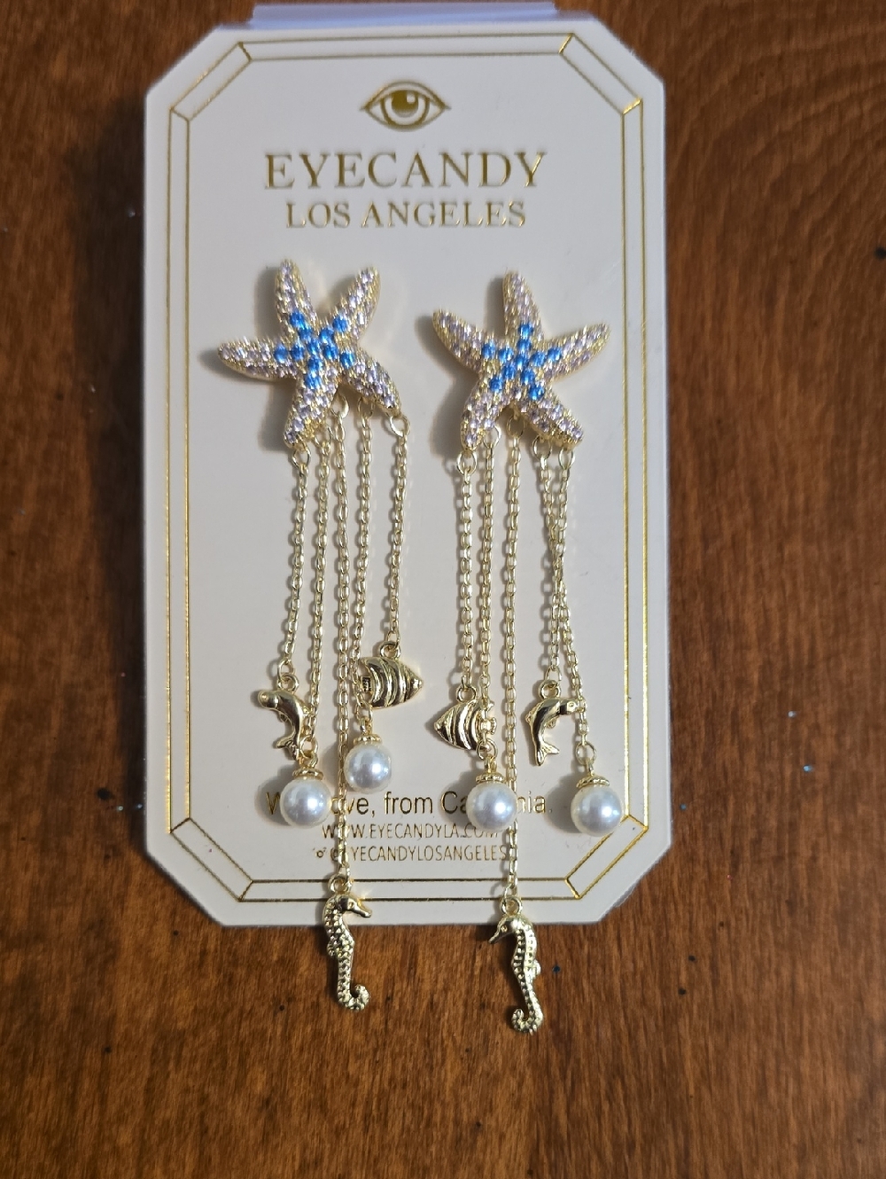 EYECANDY Los Angeles Gold Starfish Dangle Earrings with Blue Accents